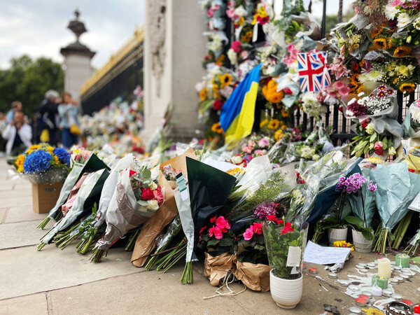엘리자베스 2세 여왕을 추모하기 위해 버킹엄 궁전 앞에 놓인 꽃다발들. [출처: Adobe Stock]