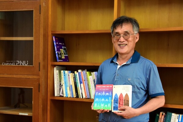 Prof. Lim Young-Ho, who is standing in front of his empty bookshelf ahead of his retirement, is holding the books that he published recently. [Jun Hyung-Seo, Reporter]