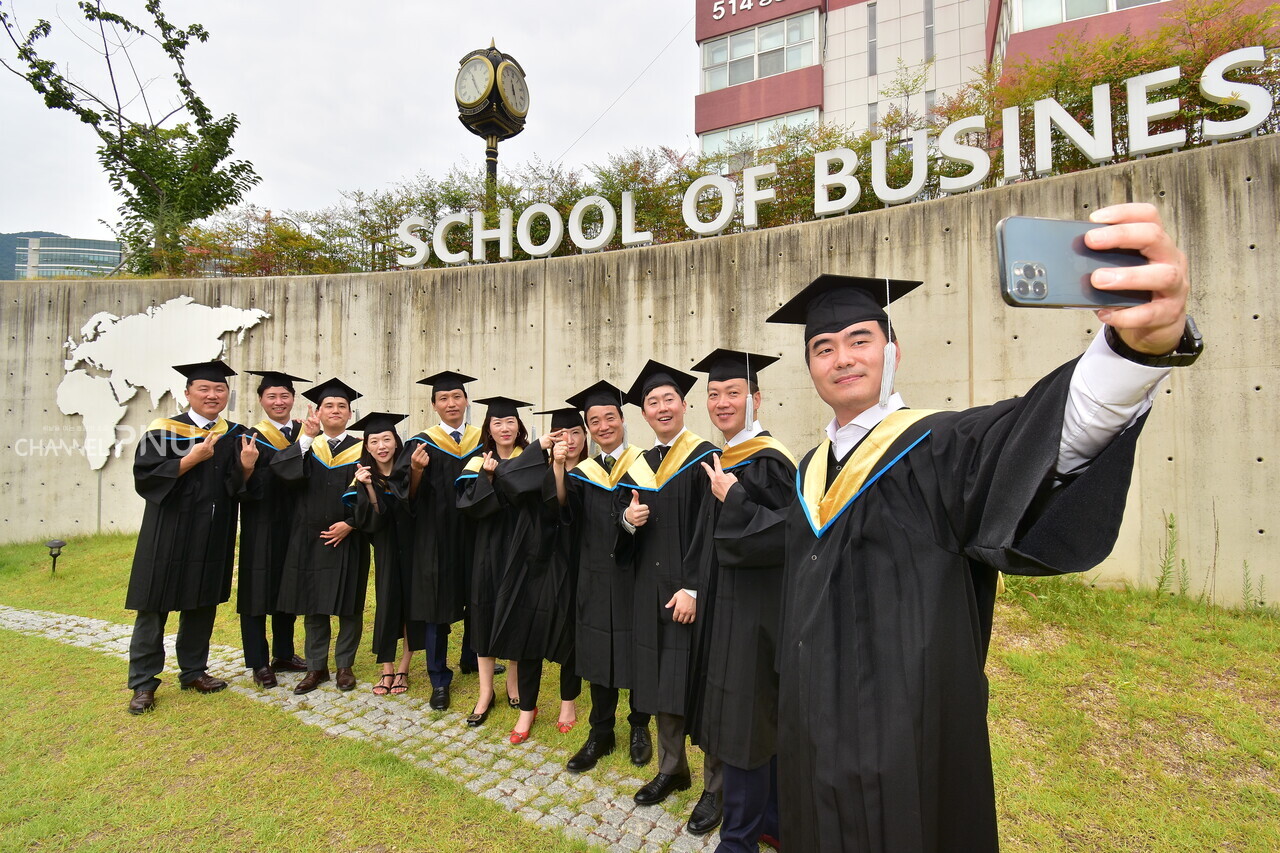 Forever, our friendship! The graduates are taking selfies in front of the Business Building. [Jun Hyung-Seo, Reporter]