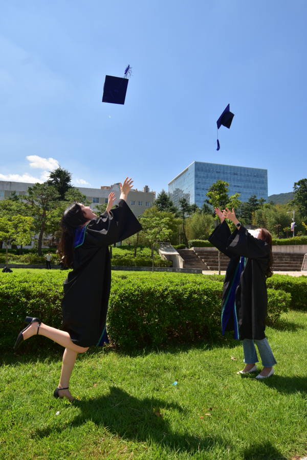 Two friends are throwing their graduation caps vigorously. They look as excited as they can be. [Jun Hyung-Seo, Reporter]