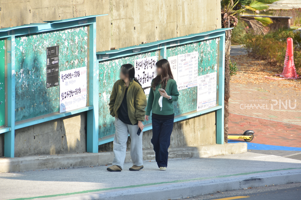 학내 시위 플래카드를 보고 지나치는 학생들. [조승완 기자]