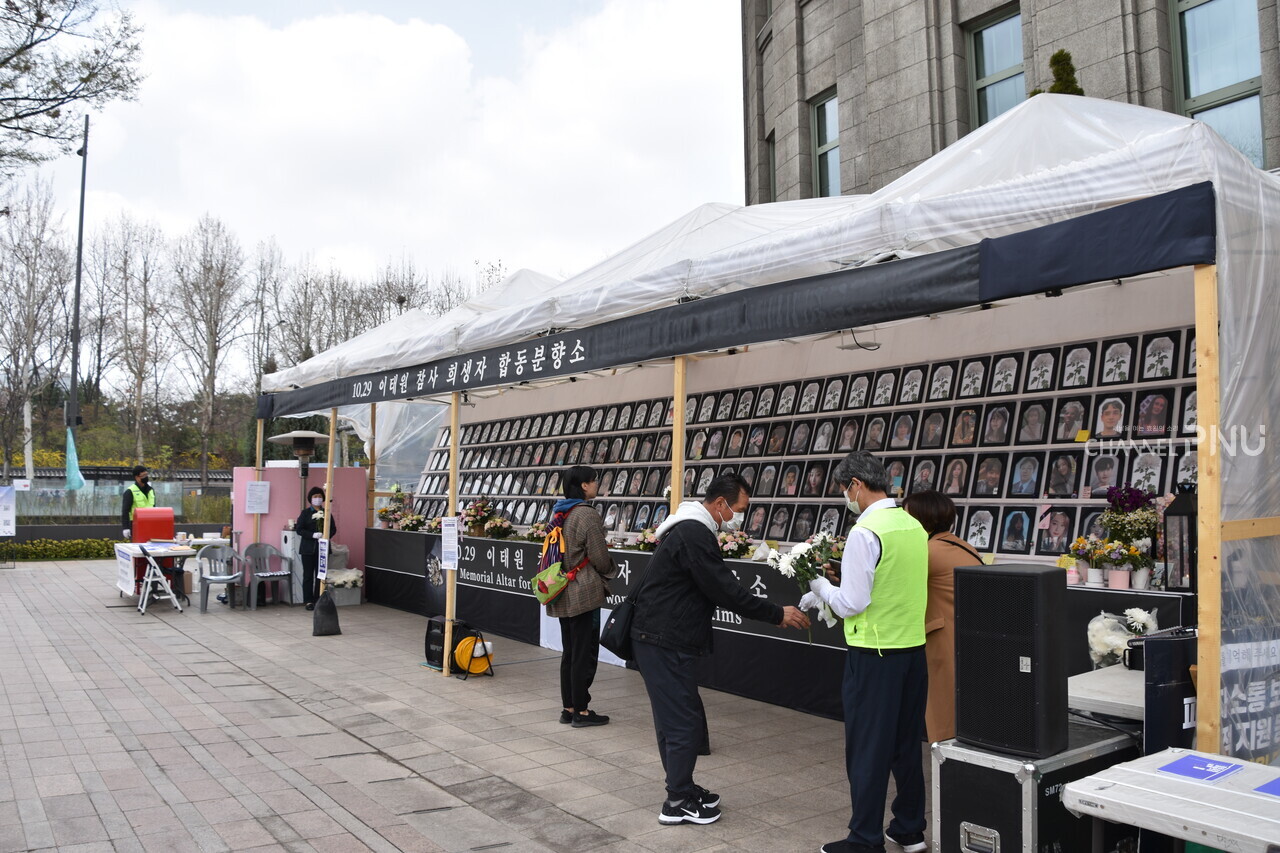 The memorial altar for the victims of the 10/29 Itaewon Halloween crowd crush located in Seoul Plaza on March 25th. Some of the citizens passing by receive chrysanthemum flowers from the bereaved families and lay a wreath. [Yoon Da-Gyo, Reporter]