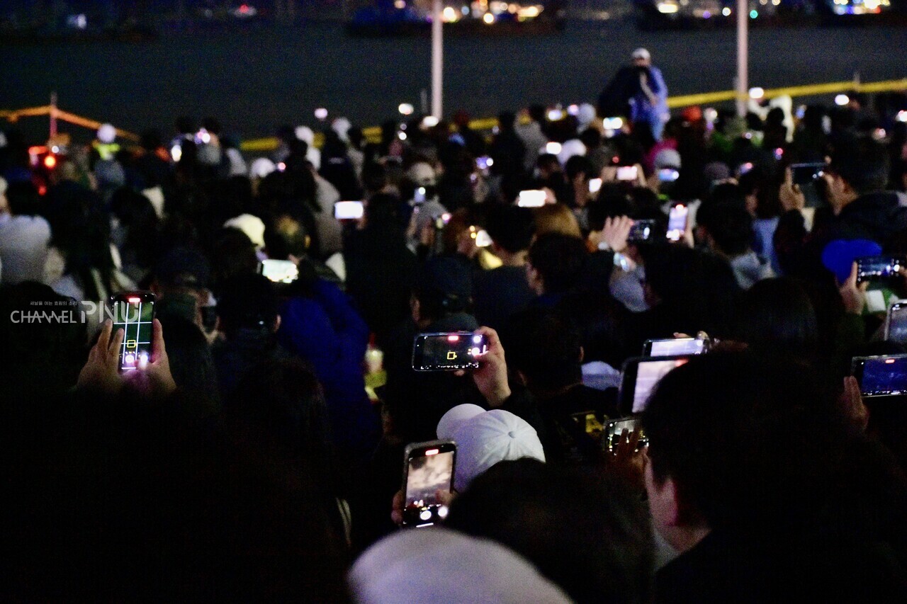 시민들이 각자의 휴대폰으로 불꽃을 담고 있다. [전형서 기자]