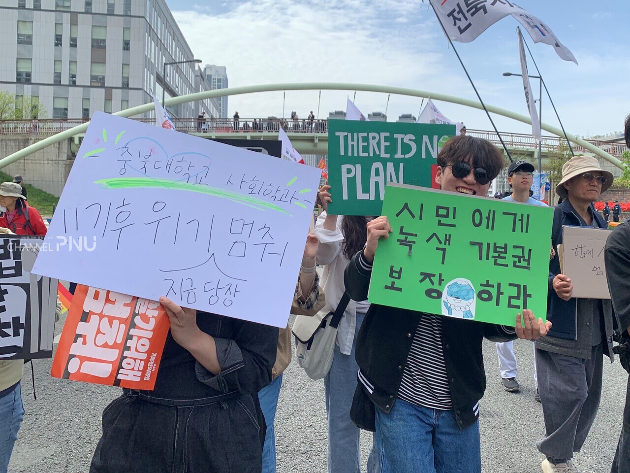 지난 4월 14일 충북대학교 사회학과 소모임 인원들이 "시민에게 녹색 기본권 보장하라"는 문구를 적은 피켓을 들고 행진하고 있다. [최선우 기자]