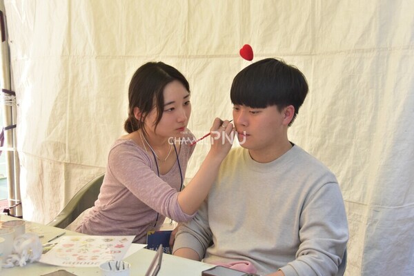 On the 18th, a student in the Department of Fine Arts is doing face painting at the booth. [Jung Hye-Eun, Reporter]