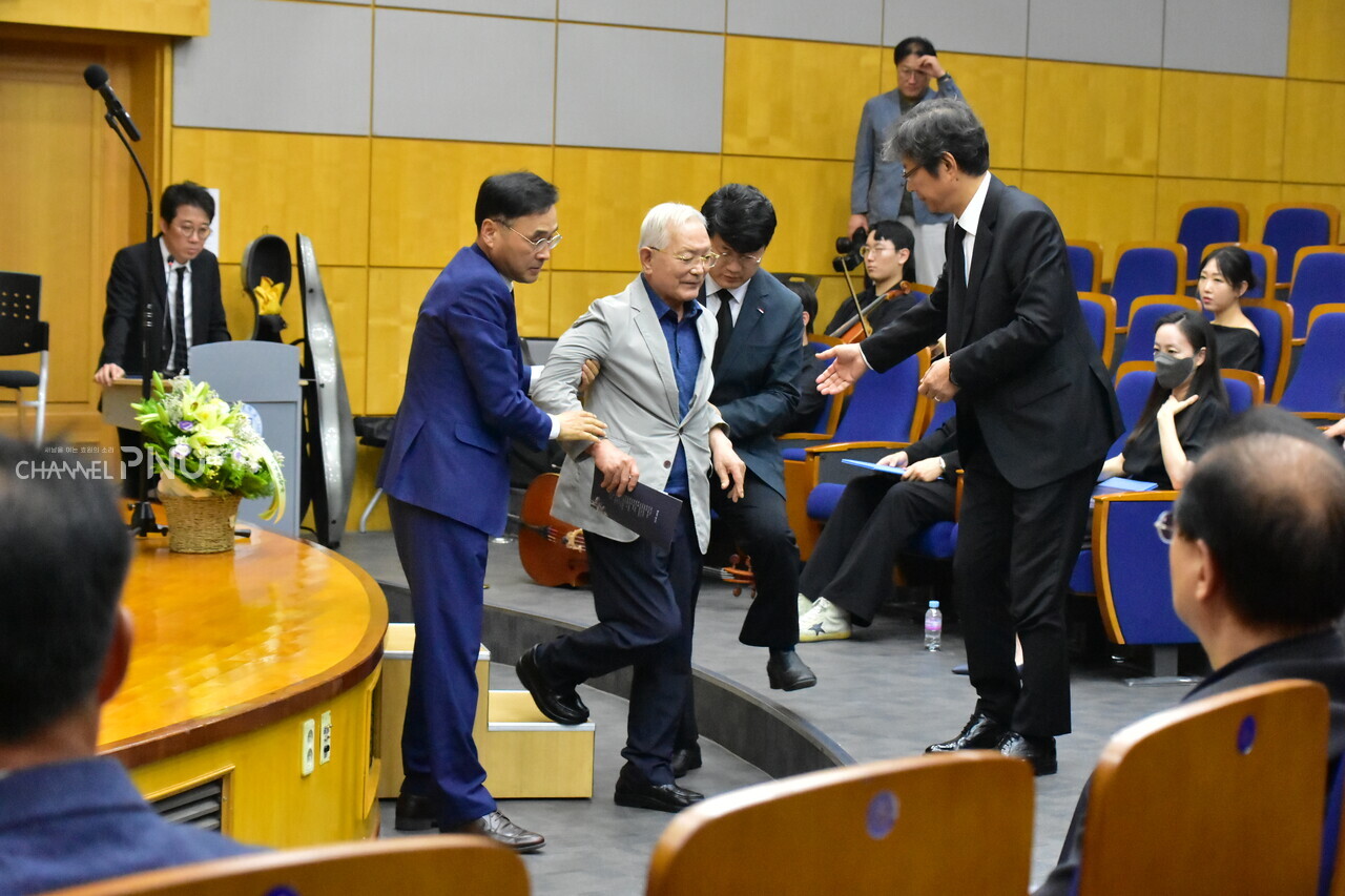 Priest Song Gi-In, received help from President Cha Jeong-In and Lee Jun-Gyu (the dean of the College of Humanities), is heading to his seat. [Jun Hyung-Seo, Reporter]
