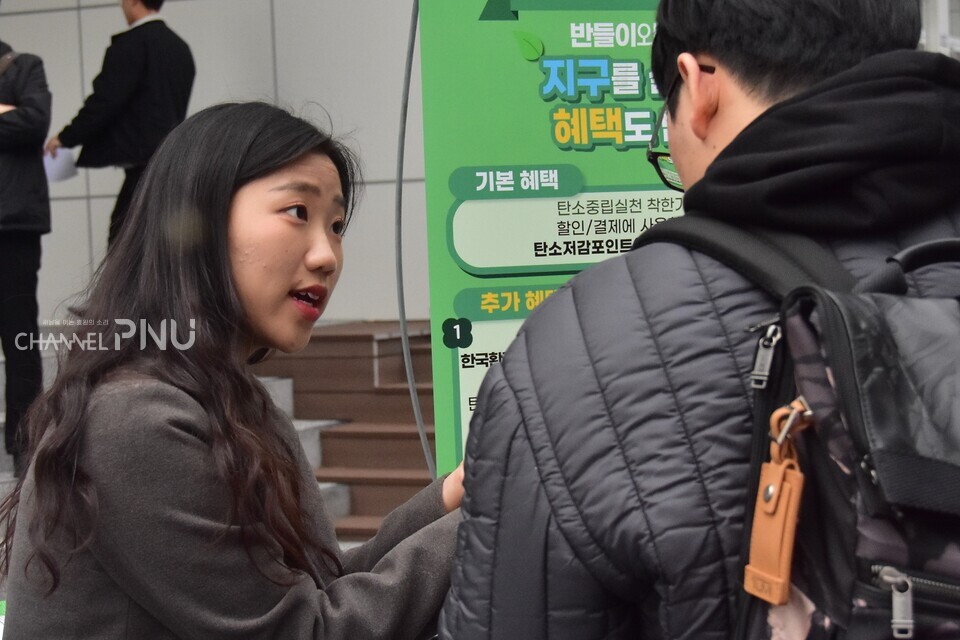 커피차 옆에서 한국환경공단이 만든 탄소중립실천 어플리케이션 '반들이'를 소개 하는 맑음부원. [최유민 기자]