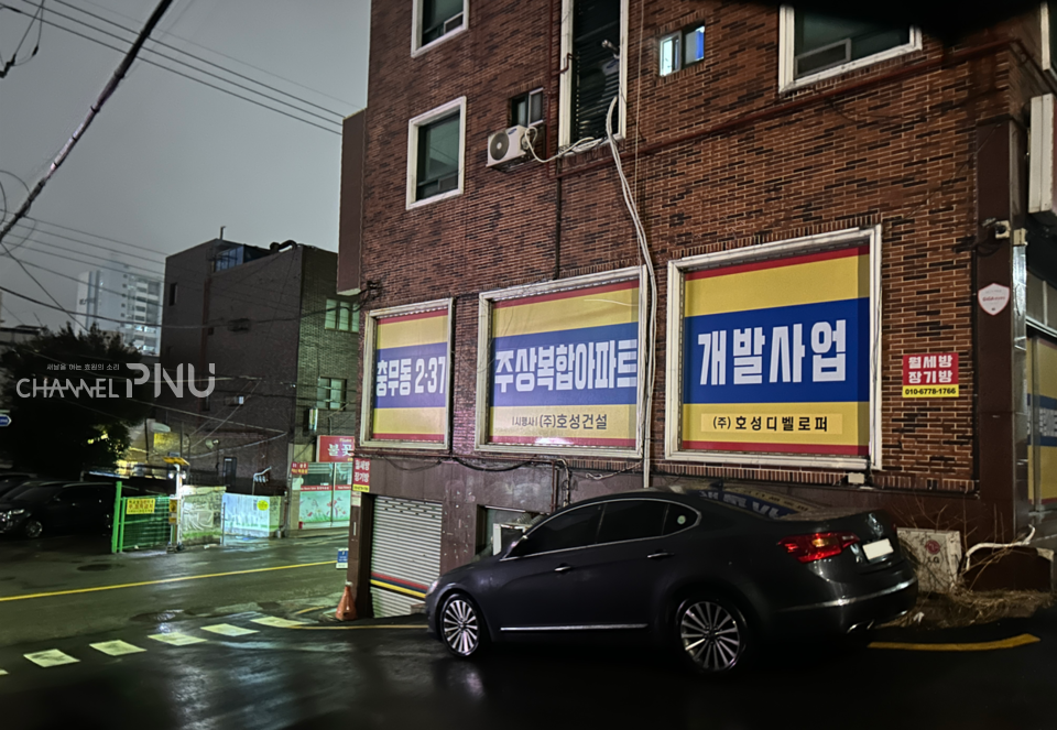 부산 완월동 한 건물에 부착된 주상복합아파트 개발 문구. [최윤희 기자]