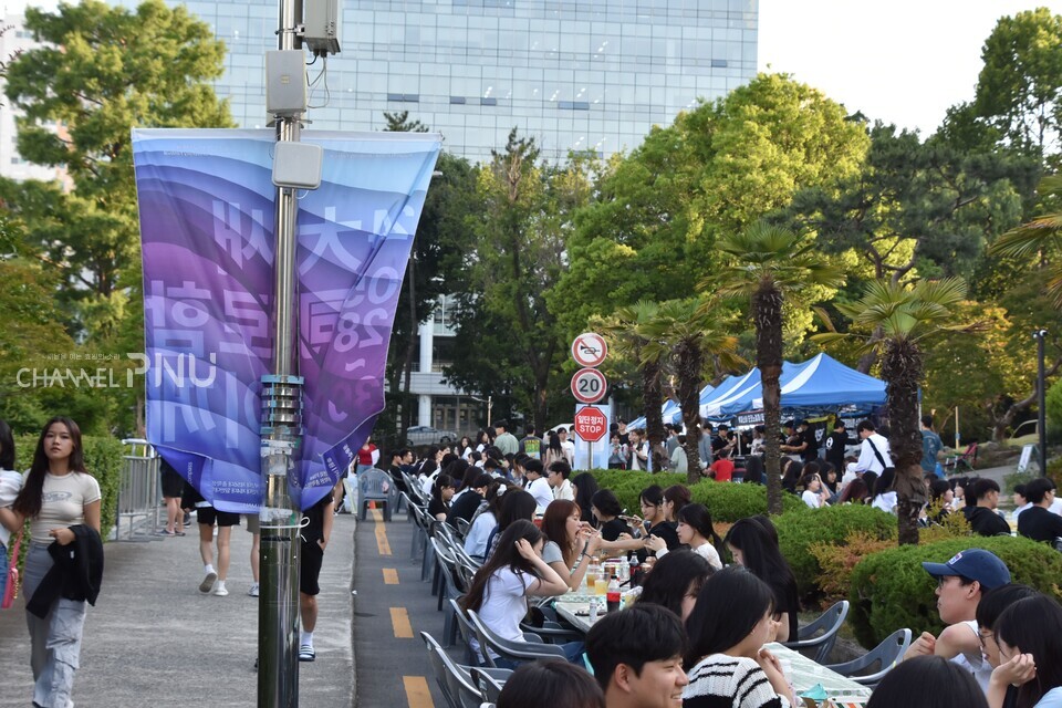 29일 인문관 도로 일대의 테이블에서 학생들이 푸드부스와 푸드트럭에서 구매한 음식을 즐기고 있다. [이수현 기자]