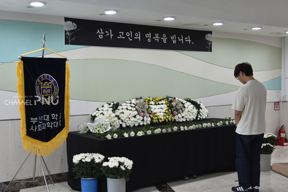 우리 대학 사회관 건물에 마련된 추모 공간. 한 학생이 추모하고 있다. [윤다교 부대신문 국장]