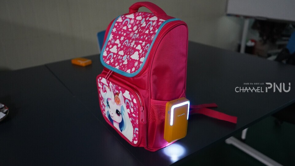 로엔코리아의 교통 안전 시스템 디바이스 '아이길'의 책가방 부착 모습.[류해주 기자]