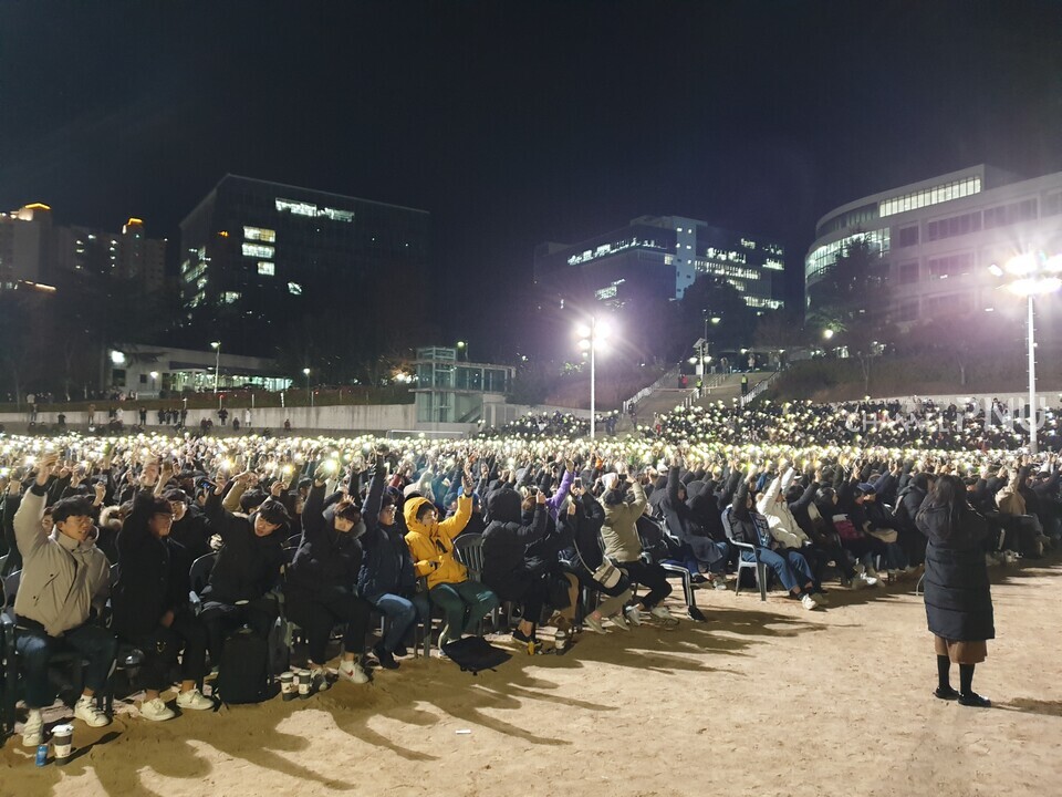 지난 2018년 12월 14일 넉터에서 진행된 학생총회에서 학생들이 일제히 손을 들고 핸드폰 불빛을 비추며 문제 해결을 위해 목소리를 내고 있다. [취재원 제공]