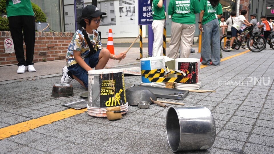 지난 9월 28일 오후 4시경 부산대학로 일대에서 공연한 '폐드럼 그루브'를 관람한 이지후(12세, 부산 금정구) 씨가 공연이 끝난 후 직접 폐드럼을 두들겨보고 있다. [황주원 기자]