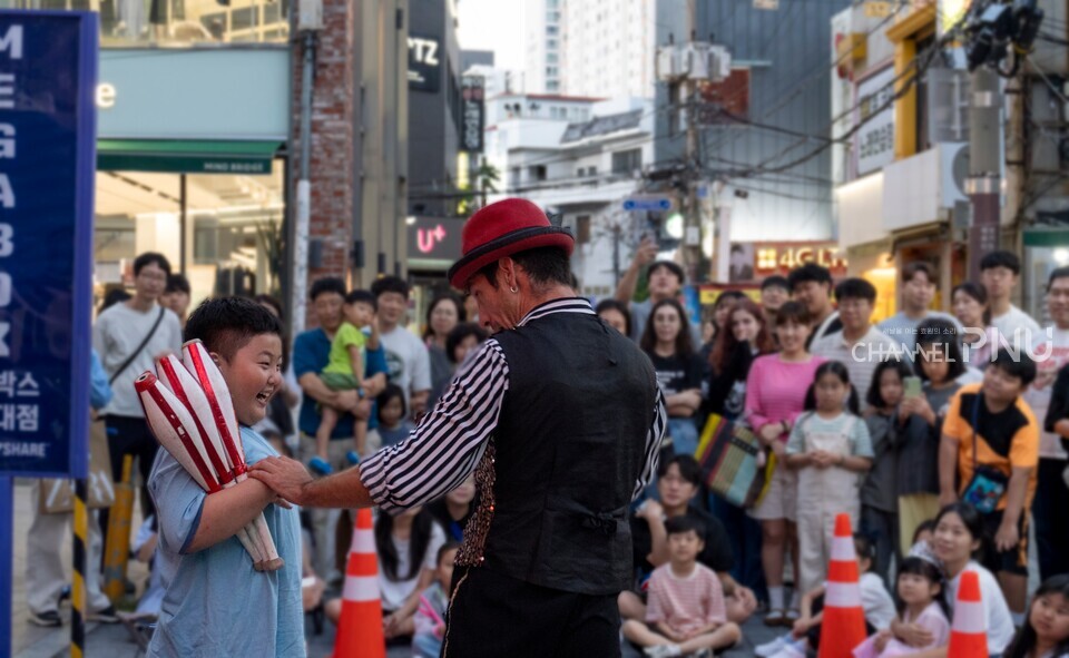 지난 9월 29일 오후 6시 30분경 부산대학로 일대에서 '서커스 맛보기' 공연 장면. 어린 행인이 공연자와 함께 서커스를 진행하고 있다. 현장에는 40명이 넘는 행인이 모여 1시간 가량 공연을 즐겼다. [조승완 전문기자]