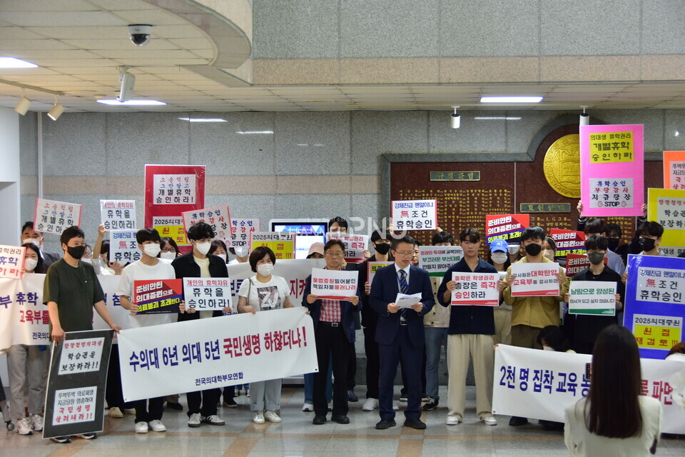 지난 10월 18일 우리 대학 대학본부에서 성명서를 낭독하는 의과대학 오세옥 교수협의회장과 피켓을 들고 있는 의대 학생 및 학부모. [윤지원 기자]