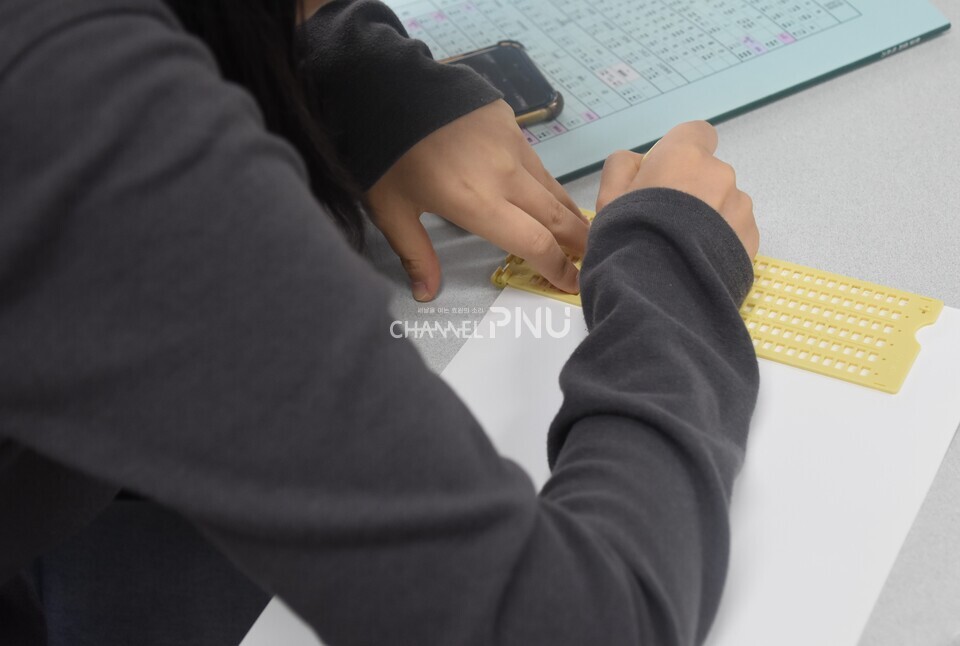 지난 11월 13일 우리 대학 장애학생지원센터가 주관한 '점자교실'에 참가한 학생이 점필을 들고 점자를 쓰고 있다. [오정린 기자]