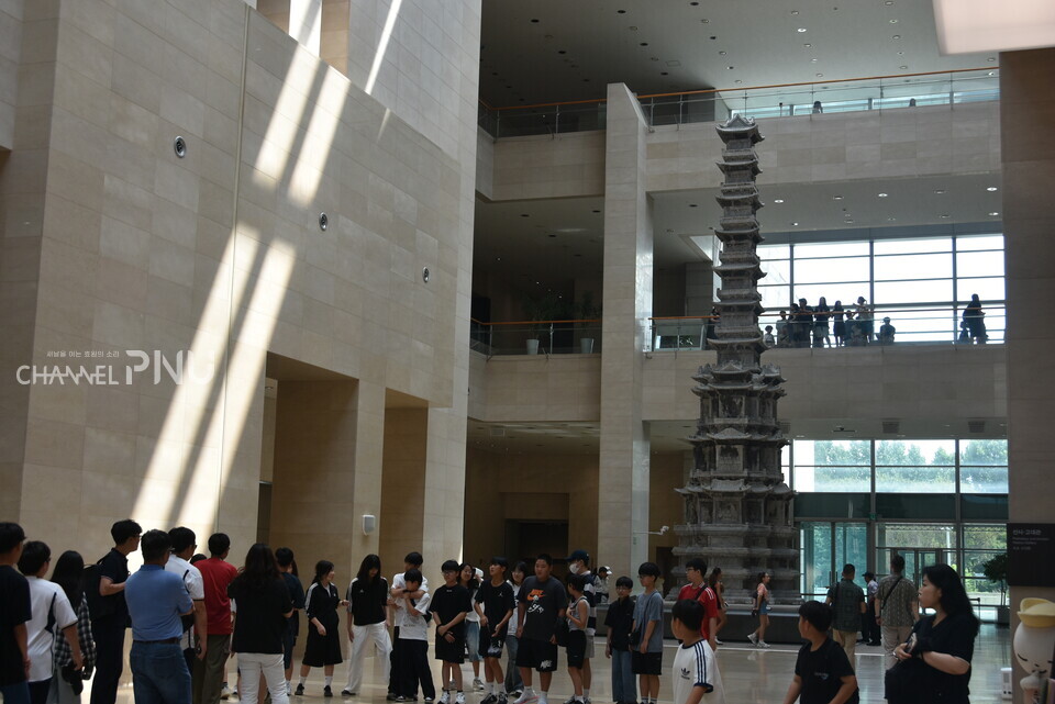 On the morning of the 21st, children pose for a commemorative photo in front of the Ten-Story Stone Pagoda from Gyeongcheonsa Temple on the first floor of the National Museum of Korea. [Yun Hae-Rin, Reporter]