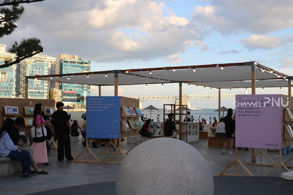 지난 9월 20일, '2025 광안리 해변도서전' 현장에 설치된 해변 독서 라운지의 모습. 사람들은 책을 구경하거나 자리를 잡고 독서를 하고 있다.  