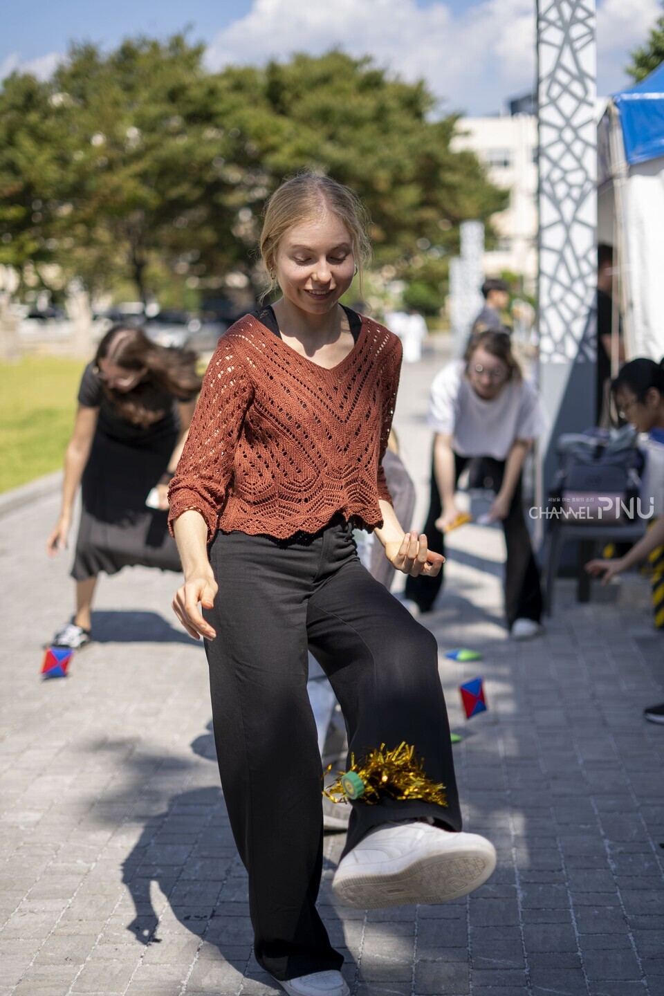 지난 10월 1일 열린 ‘PNU K-Festival’에서 한 외국인 유학생이 박물관 새벽뜰 앞 부스에서 제기를 차며 한국 전통 놀이 문화를 즐기고 있다. [임현규 전문기자]
