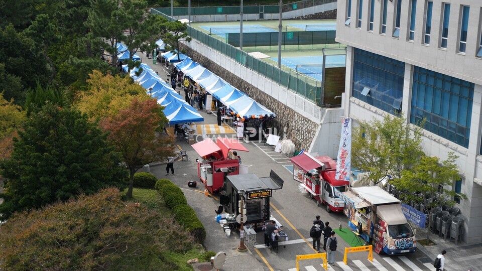 지난 10월 30일 경맥제가 열린 우리 대학 경제통상관 아래 도로. 부스 천막과 푸드트럭이 자리하고 있다. [박선영 기자]