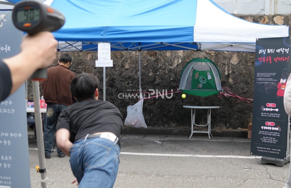 지난 10월 30일 경제통상관 아래 도로 입구에서 진행된 경맥제. 학과 부스에서 한 학생이 공을 던지자 스태프를 맡은 학생이 공의 구속을 측정하고 있다. [박선영 기자]