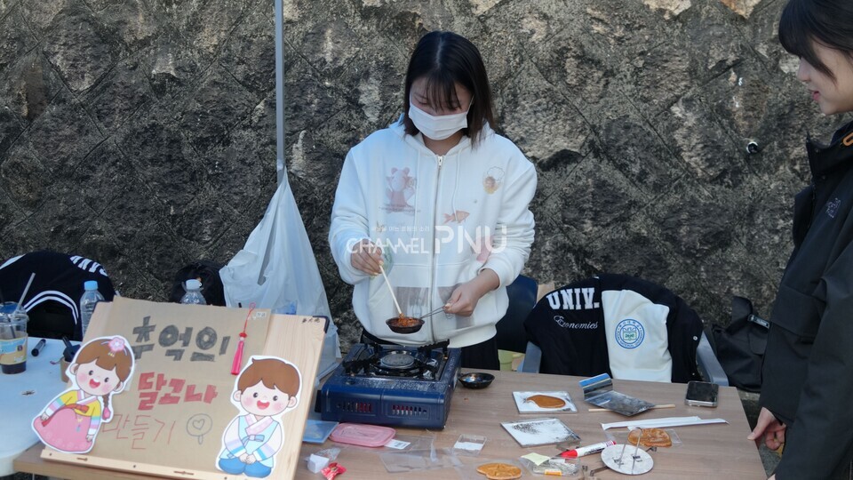 지난 10월 30일 경제통상관 아래 도로 입구에서 진행된 경맥제. 한 학생이 달고나를 만들고 있다. [박선영 기자]