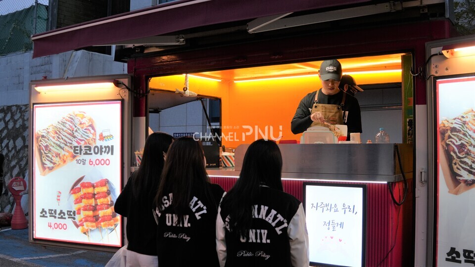 지난 10월 30일 경제통상관 아래 도로 입구에서 진행된 경맥제의 푸드트럭에서 학생이 타코야끼를 사고 있다. [박선영 기자]