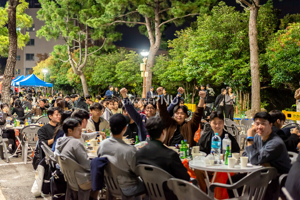 ​지난 10월 30일 경제통상관 아래 도로 입구에서 진행된 경맥제. 공연 프로그램을 즐기며 음식을 먹는 학생들. 몇몇 학생들은 포즈를 취하고 있다. [송민수 기자]