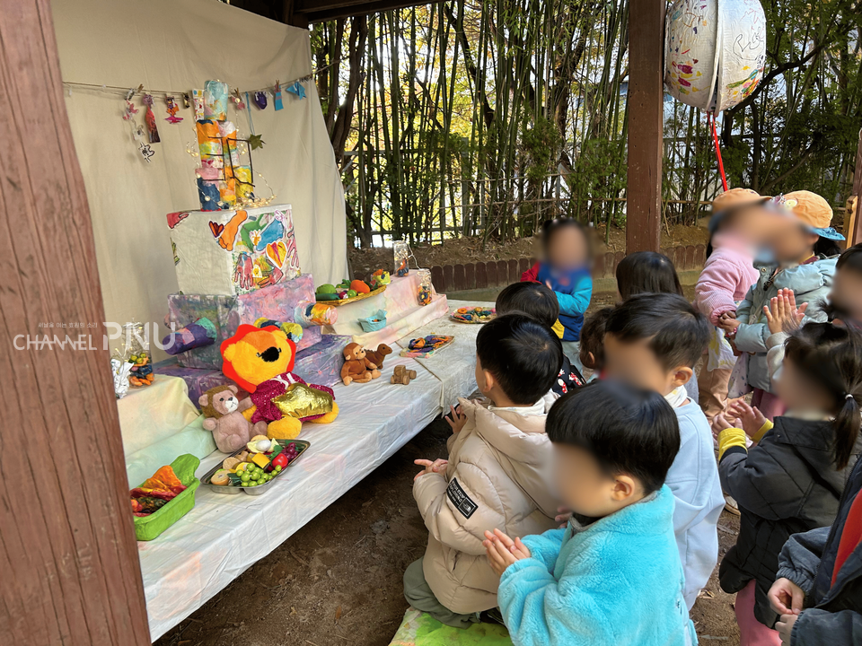 지난 11월 11일부터 13일간 우리 대학 부설어린이집 바깥놀이터에 마련된 어린이집 30주년 생일상 앞에 아이들이 모여있다. [우리 대학 부설어린이집 제공]