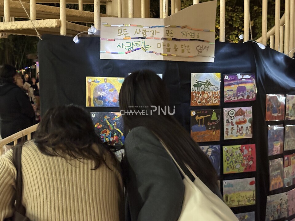 지난 11월 11일부터 13일간 열린 우리 대학 부설어린이집 행사에서 아이들의 졸업 작품으로 만든 엽서를 사람들이 보고 있다. [우리 대학 부설어린이집 제공]