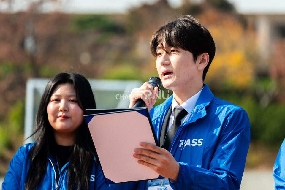 ​지난 11월14일 기호 1번 ‘PASS’의 최연우(식품영양학, 21) 정후보가 우리대학 시월광장 앞에서 지나가는 학생들을 상대로 마이크 유세중이다. [송민수 기자]
