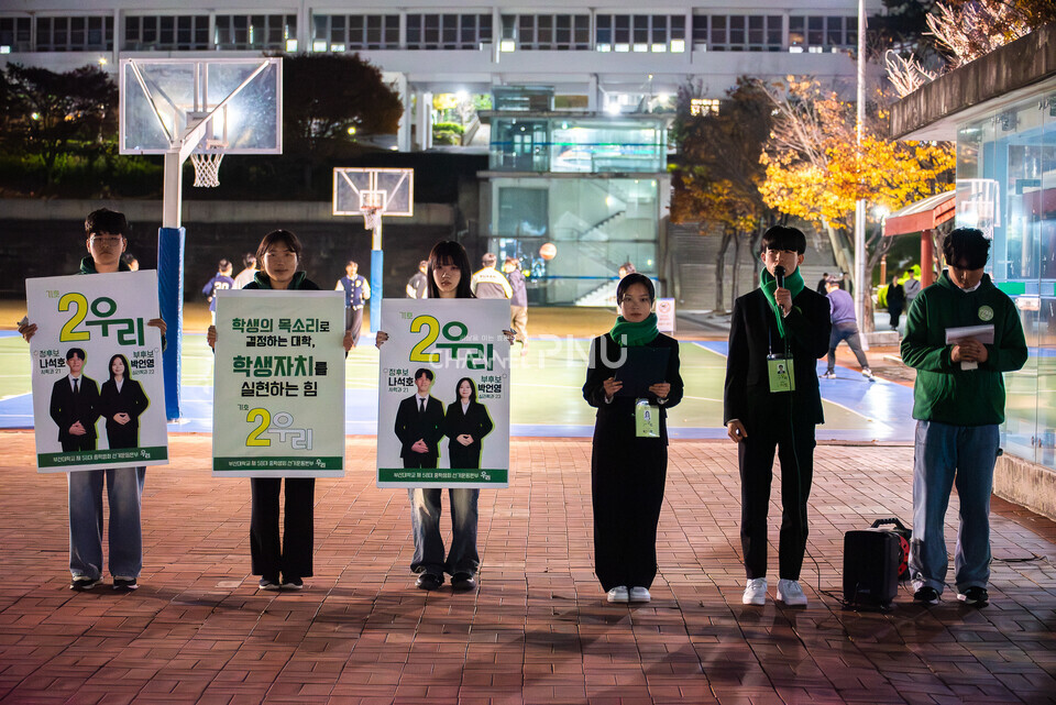 ​지난 11월 17일 기호 2번 ‘우리’ 나석호(사학, 21) 정후보와 박언영(심리학, 23) 부후보가 우리 대학 시월광장에서 마이크 유세를 하고 있다. [송민수 기자]