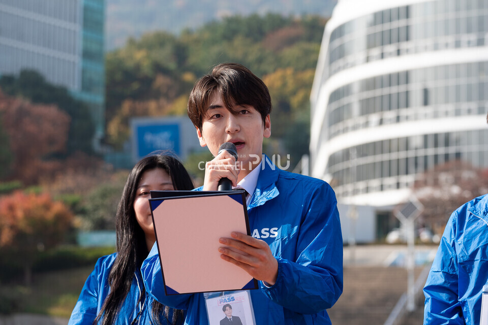 ​지난 11월14일 기호 1번 ‘PASS’의 최연우(식품영양학, 21) 정후보가 우리대학 시월광장 앞에서 지나가는 학생들을 상대로 마이크 유세중이다. [송민수 기자]